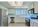 Bright kitchen featuring stainless steel appliances, white cabinetry, and abundant natural light at 750 E Northern Ave # 2088, Phoenix, AZ 85020