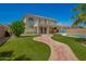 A two-story home with a brick walkway and a backyard with a pool and well-manicured lawn at 7923 W Hess Ave, Phoenix, AZ 85043