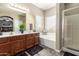 Bathroom featuring a double sink vanity, large mirror, soaking tub, and glass enclosed shower at 7923 W Hess Ave, Phoenix, AZ 85043