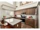 Open-concept kitchen features stainless appliances, granite countertops, kitchen island, and high ceilings with large windows at 7923 W Hess Ave, Phoenix, AZ 85043