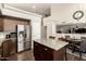 Kitchen with stainless steel appliances, granite countertops, kitchen island with barstool seating, and an adjoining dining area at 7923 W Hess Ave, Phoenix, AZ 85043