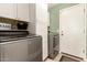 A well-organized laundry area with modern appliances and ample storage cabinets and a door at 7923 W Hess Ave, Phoenix, AZ 85043