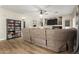 Open living room with a large sectional couch, wooden floors, fireplace, and a bookshelf with games and movies at 7923 W Hess Ave, Phoenix, AZ 85043