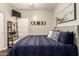 Stylized main bedroom with dark blue bedding and wall art with hardwood floors at 7923 W Hess Ave, Phoenix, AZ 85043