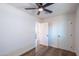 Neutral bedroom featuring wood-look floors, a ceiling fan, and an open doorway to another room at 826 S Drew St, Mesa, AZ 85210