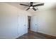 An empty bedroom with a ceiling fan, two closets, and a view of an adjacent room through the open door at 826 S Drew St, Mesa, AZ 85210