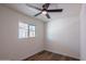 Bright bedroom with wood-look flooring, a ceiling fan, and a window providing natural light at 826 S Drew St, Mesa, AZ 85210
