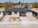Charming home with a dark roof, a white picket fence, mature trees, and a rock fire pit in front at 826 S Drew St, Mesa, AZ 85210