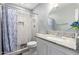 Bathroom featuring a shower with geometric tile, granite countertop vanity and round mirror at 8341 W Cypress St, Phoenix, AZ 85037