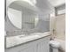 Bathroom with granite countertop, large mirror and tub/shower with white tile at 8341 W Cypress St, Phoenix, AZ 85037