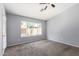 Bedroom with neutral carpet, ceiling fan, window with view of backyard and a door at 8341 W Cypress St, Phoenix, AZ 85037