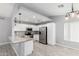 Modern kitchen with white cabinets, stainless steel appliances, granite countertops and wood-look tile floors at 8341 W Cypress St, Phoenix, AZ 85037