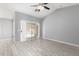 Bright living area features wood-look tile floors, vaulted ceiling and neutral gray paint with patio access at 8341 W Cypress St, Phoenix, AZ 85037