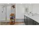 Well-lit bathroom with a shower, soaking tub, dark vanity with modern fixtures and wooden shelving at 880 S 150Th Dr, Goodyear, AZ 85338