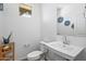 Bright bathroom featuring a white sink, toilet, and decorative wall art for a serene atmosphere at 880 S 150Th Dr, Goodyear, AZ 85338