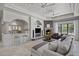 Inviting living room featuring a stone fireplace, comfortable seating, a wet bar, and a view of the lush backyard at 9290 E Thompson Peak Pkwy # 470, Scottsdale, AZ 85255