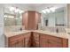 Bathroom featuring double sinks, granite counters, wood cabinetry, and a large mirror at 10029 S 44Th St, Phoenix, AZ 85044