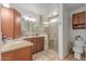 Bathroom featuring a walk-in shower with glass enclosure, granite counters, and wood cabinetry at 10029 S 44Th St, Phoenix, AZ 85044
