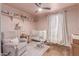 Charming Bedroom featuring a crib, rocking chair, and shelves for displaying decorative items at 10029 S 44Th St, Phoenix, AZ 85044