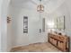Bright foyer with travertine floors, white walls, a modern light fixture, and wood furniture at 10029 S 44Th St, Phoenix, AZ 85044