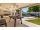 Expansive covered patio with ping pong table, overlooking a pool and lush backyard, ideal for entertaining at 10029 S 44Th St, Phoenix, AZ 85044