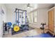 Exercise room with weight training equipment, rubber mat flooring, and natural light at 10420 E Morning Vista Ln, Scottsdale, AZ 85262