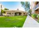 Community clubhouse with lush green lawn and convenient walkway at 11640 N Tatum Blvd # 2012, Phoenix, AZ 85028