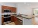 Modern kitchen with stainless steel appliances and a view into the living room at 11640 N Tatum Blvd # 2012, Phoenix, AZ 85028