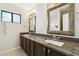Bathroom features double sinks, granite countertop, and stylishly framed mirrors at 1192 E Sunset Dr, Casa Grande, AZ 85122