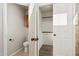 A half bathroom and open closet featuring wood-look flooring, toilet, and open closet at 1192 E Sunset Dr, Casa Grande, AZ 85122