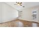 Bright bedroom with a ceiling fan, wood-look flooring, a window, and a door to the backyard at 1192 E Sunset Dr, Casa Grande, AZ 85122