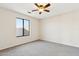Bright bedroom featuring neutral carpet and a window with outdoor views. Ceiling fan included at 1192 E Sunset Dr, Casa Grande, AZ 85122