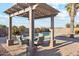 Backyard includes a charming pergola with seating, perfect for outdoor relaxation at 1192 E Sunset Dr, Casa Grande, AZ 85122