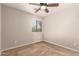 Bedroom with neutral walls, carpet, ceiling fan, and window overlooking the yard at 125 N Sunvalley Blvd # 119, Mesa, AZ 85207