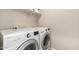 Functional laundry room featuring a washer and dryer with overhead shelving for storage at 125 N Sunvalley Blvd # 119, Mesa, AZ 85207