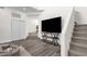 View of living room with wood-look floors, a television and adjacent staircase at 12852 N Mountainside Dr # 2, Fountain Hills, AZ 85268