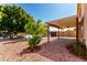 Backyard featuring a covered patio, stone landscaping, a tree, and waterfront access with a private dock at 1379 E Butler Cir, Chandler, AZ 85225