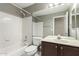 Well-lit bathroom with a shower-tub combo, dark cabinets, and a large mirror enhancing the room's space at 1379 E Butler Cir, Chandler, AZ 85225