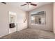 Carpeted bedroom features a ceiling fan and a large window, as well as a bathroom at 1379 E Butler Cir, Chandler, AZ 85225