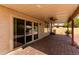 Relax on the covered patio with a ceiling fan, brick flooring, and sliding glass doors offering seamless indoor/outdoor living at 1379 E Butler Cir, Chandler, AZ 85225