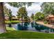 Scenic view of the community pond surrounded by lush landscaping and mature trees at 1379 E Butler Cir, Chandler, AZ 85225