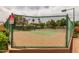 View of the community tennis court surrounded by a fence, lush greenery, and beautiful landscaping at 1379 E Butler Cir, Chandler, AZ 85225