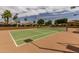 Well-lit tennis court with clear playing lines and mature trees, perfect for year-round enjoyment at 1379 E Butler Cir, Chandler, AZ 85225