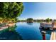 Scenic waterfront view featuring a private dock, serene lake, and lush trees with neighborhood homes in the background at 1379 E Butler Cir, Chandler, AZ 85225