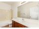 Bright bathroom featuring a vanity with solid surface top, large mirror, tub-shower, and toilet at 15792 W Desert Mirage Dr, Surprise, AZ 85379