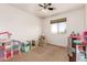 Spacious bedroom features a ceiling fan and large window; staged as a playroom at 15792 W Desert Mirage Dr, Surprise, AZ 85379