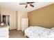 Cozy bedroom with neutral walls, ceiling fan, wardrobe, and an open doorway to a hallway and bathroom at 15792 W Desert Mirage Dr, Surprise, AZ 85379
