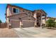 Inviting two-story home featuring a three-car garage and well-manicured front yard landscaping at 15792 W Desert Mirage Dr, Surprise, AZ 85379