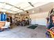Spacious garage with ample storage, ATVs and lawn equipment with overhead door at 15792 W Desert Mirage Dr, Surprise, AZ 85379