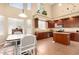 Kitchen with wood cabinets, kitchen island, stainless steel appliances, and large windows at 15792 W Desert Mirage Dr, Surprise, AZ 85379